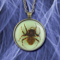 This pendant holds a glowing acrylic stone with a spider hanging from a 24" long adjustable antique brass chain
