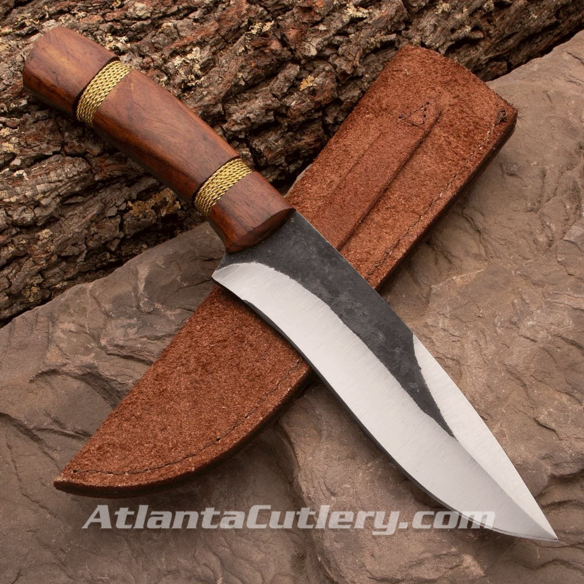 Bushcraft knife with full profile tang carbon steel blade, wood scales with wrapped brass wire, and leather sheath