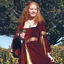 burgundy cotton velvet dress has hand-sewn trim with gold sequins on the sleeves and the waistline and gold front panel
