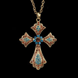 Cross pendant with over 60 faux aquamarine, sapphire, and topaz crystals on adjustable gold metal chain with a clasp