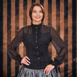 hourglass blouse has sheer shoulders and sleeves, solid midsection, and wide lace down the front, on the collar, and elastic cuffs
