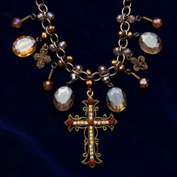 choker has faux pale topaz, fleur-de-lis and cross pendants centered by a large brass cross with faux rubies and yellow diamonds