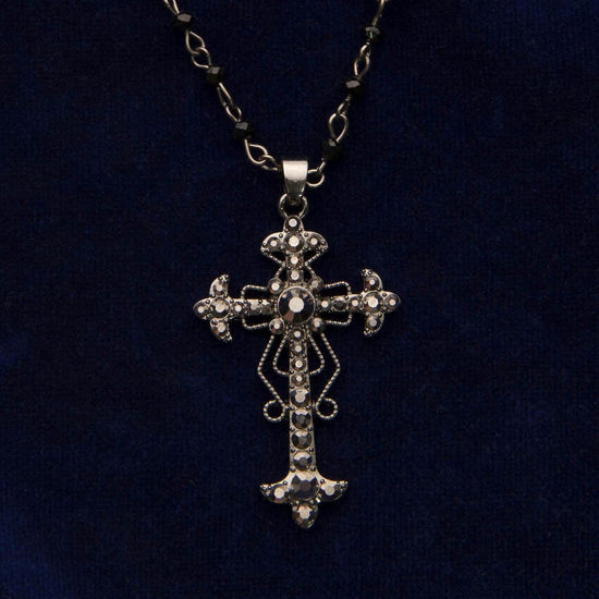 dark gray metal cross has faceted faux grey onyx and necklace is segmented with black, faceted beads
