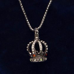 Necklace has heavy chain and mini crown pendant bejeweled with faux rubies, diamonds, and emeralds