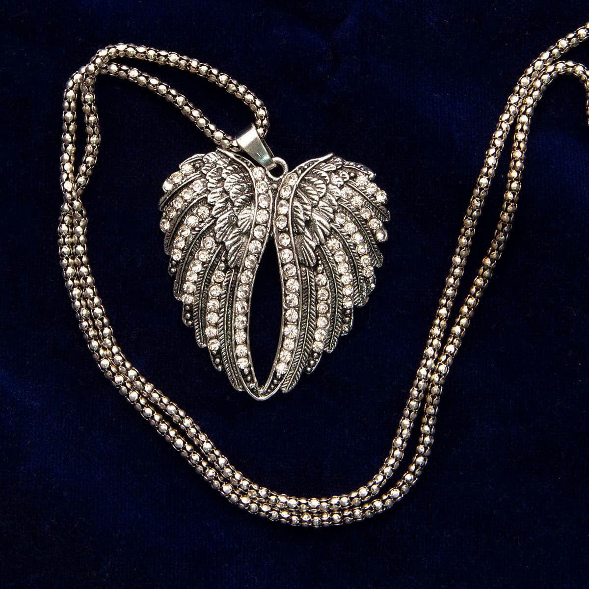 angel wings pendant has sparkling faux diamonds and hangs from a long, heavy silver finish chain