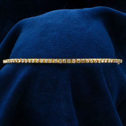 The jewels in this rhinestone headband sparkle brilliantly against the gold metal band
